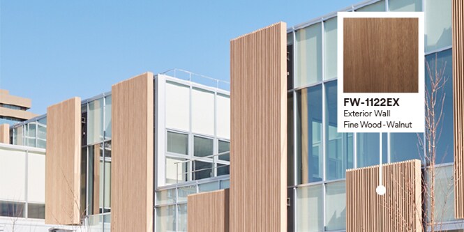 Exterior of building with glass and wood façade featuring product callout of Walnut DINOC Exterior film.
