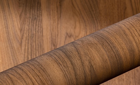 Roll of wood grain DINOC film on wood background
