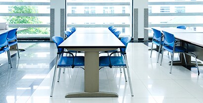 Light streams in via windows with protective film on the tables & chairs, which protect the students
