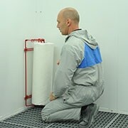 Man using a dirt trap applicator and starting applying the dirt trap protection material on a wall