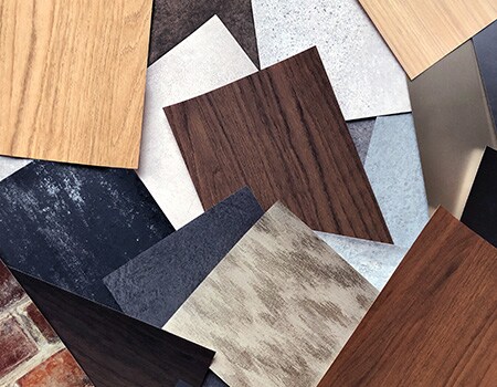 Array of surface finish samples with various wood grains, metallic tones and patterns.
