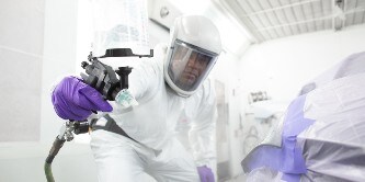 Painter spraying on a car area using the 3M performance spray gun
