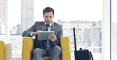 A man looks out of a sunny office window of a building covered with 3M™ Sun Control Window Film.
