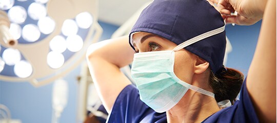 clinicain putitng on surgical mask
