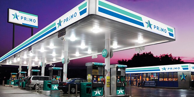 Gas station with vivid backlit blue and green graphics and signage
