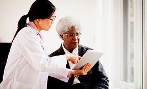physician showing patient information on a tablet
