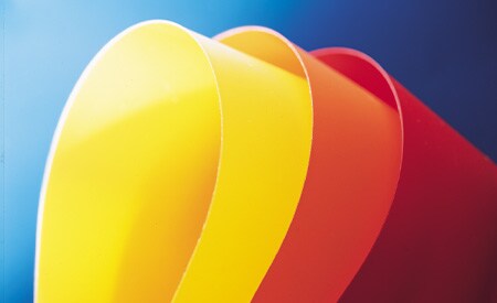 Curved samples of yellow, orange, and red solid color films on blue background
