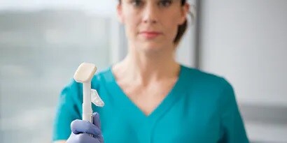 Nursing holding on to the Cavilan Advanced Skin Protection applicator
