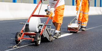 Road marking tape being applied to road
