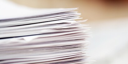 large stack of papers on a desk
