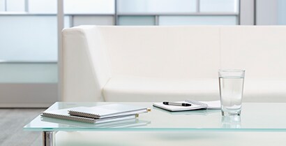 3M™ Glass Finishes cover windows in a hotel lobby with a white couch and table.
