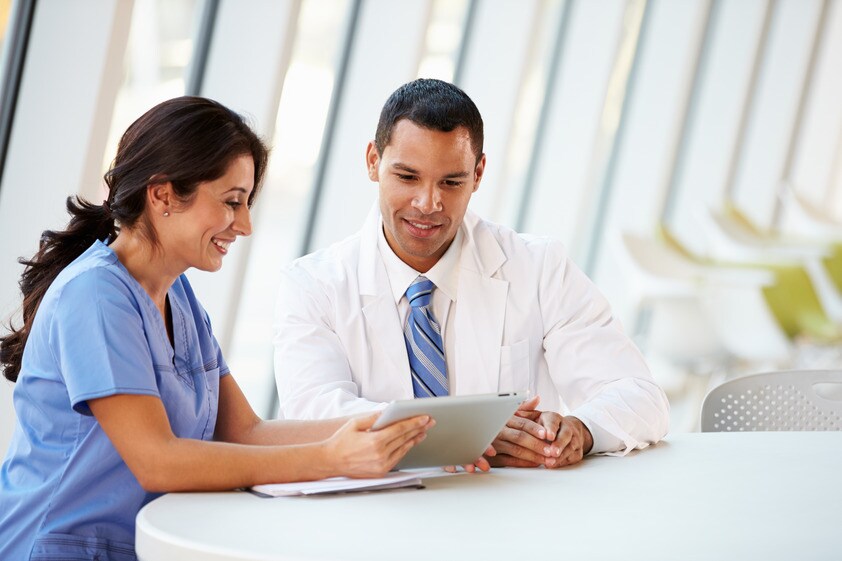 nurse looking at tablet/laptop without stethoscope around neck
