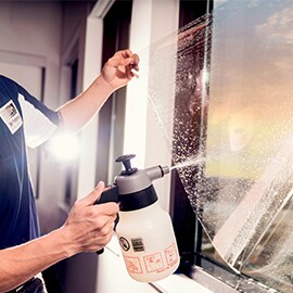 A person installing 3M™ Building Window Film