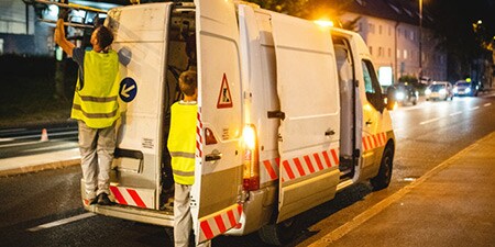 Van at the side of a road with reflective chevron markings
