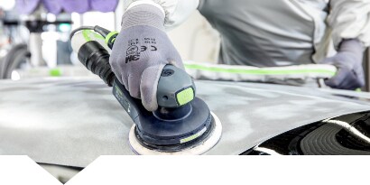 Technician sanding a damaged car panel
