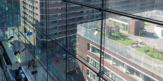 Workers on scaffolding installing Window FIlm on glass facade
