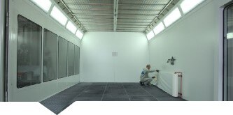  Man applying 3M Dirt Trap protection material on the walls of a paint booth

