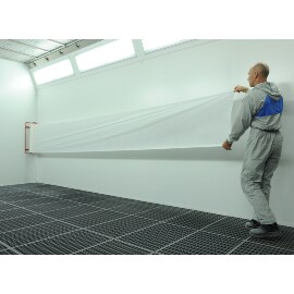 Man applying 3M dirt trap on a wall of a paint booth 
