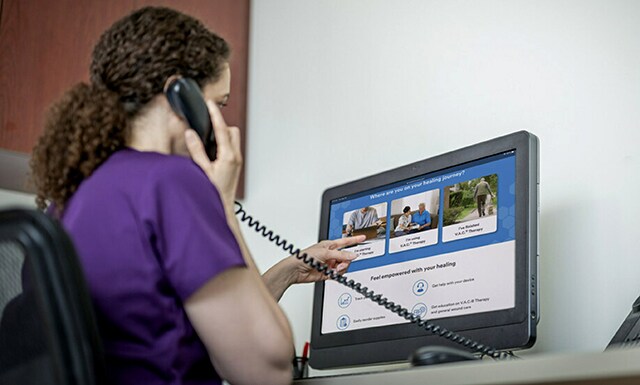 A woman pointing at a computer screen
