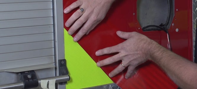  Person applying reflective sheeting to a fire engine
