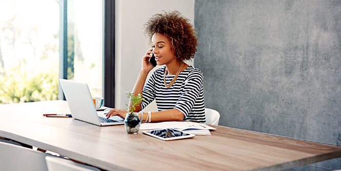 Person on the phone while using a laptop
