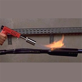 A worker using a flame torch on electric tape