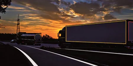 Truck on a dark road with visible conspicuity markings
