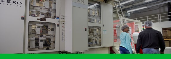 Workers walking past a flexographic press