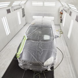 A car in a paint booth during forced drying process