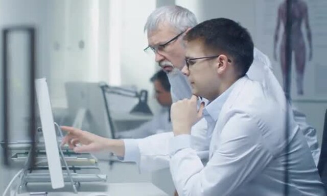 Two physicians looking at a computer
