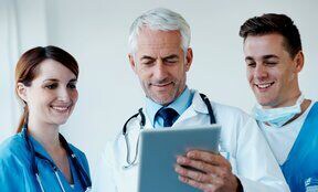 health care team discussing information on a tablet

