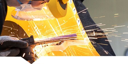 Technician cutting a metal car body part
