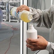 Man mixing liquid soap with water using a spray bottle