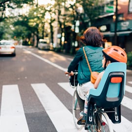 Parent and child riding a bicycle on a road