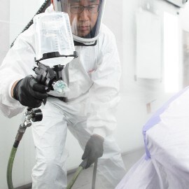 A Male Painter spraying car primer using a 3M Performance Spray Gun