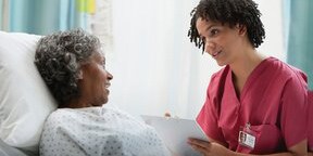 a doctor talking to a patient in a hospital bed
