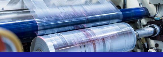 Clear packaging running through a press