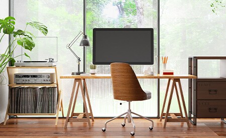 Desk setup facing wall of windows covered in 3M privacy window films
