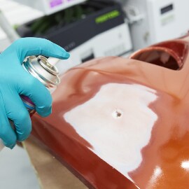 Spraying adhesion promoter on a cracked area of a bumper